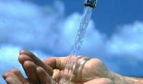 hands under a water tap against a blue sky
