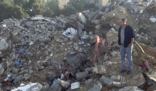 Saad Ismail standing in the ruins of the family home where six family members were killed