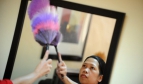 Woman dusting off mirror