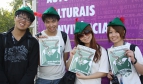 Four people with Robin Hood Tax hats and posters
