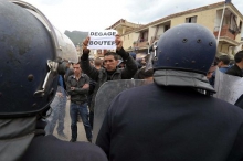 Un manifestant tient une pancarte sur laquelle est écrit « Dégage Boutef » (Abdelaziz Bouteflika) durant une manifestation appelant au boycott de l’élection présidentielle algérienne à Bejaia, le 5 avril 2014. (AP Photo/Sidali Djarboub)