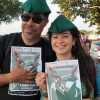 A couple  holding Robin Hood Tax posters and wearing Robin Hood caps